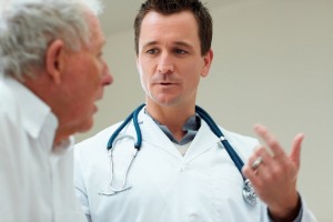 Handsome young doctor speaking to a senior man , explaining the diagnosis